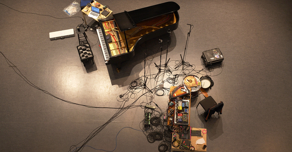 An ariel image of a piano on a stage with recording equipment 