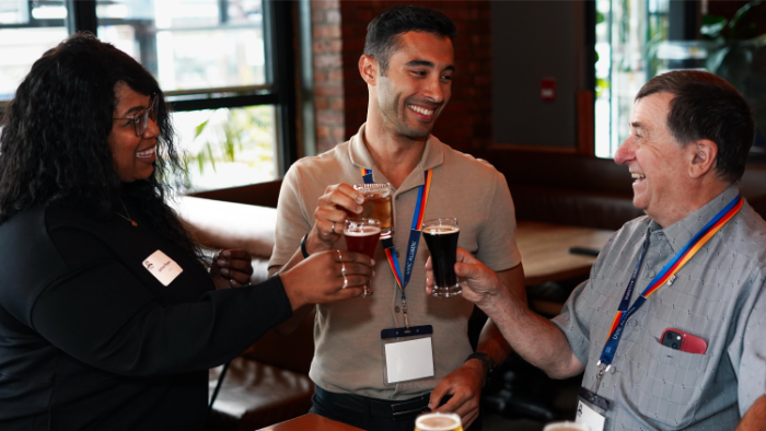 Three UVic alumni cheersing at a pub night event