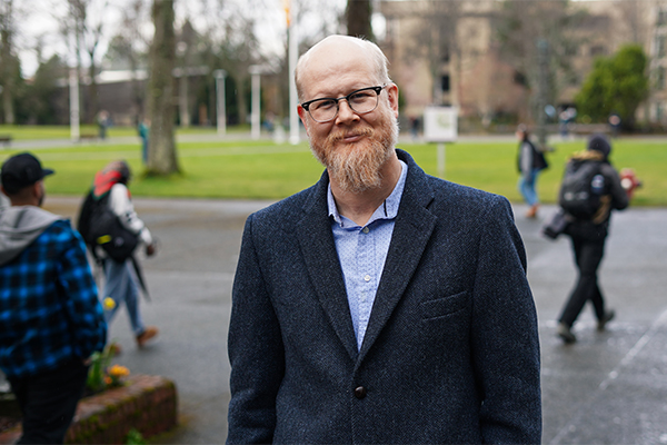 David Leitch poses on a  busy campus.