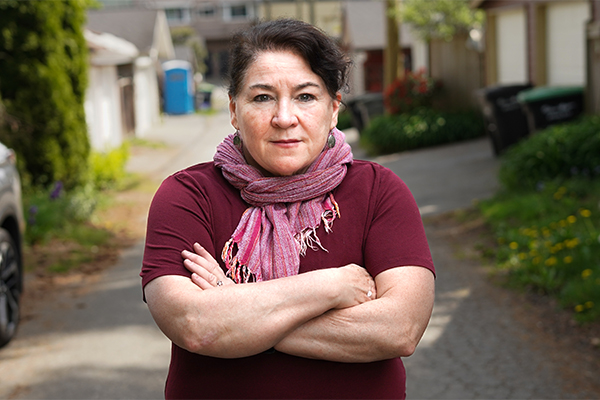 Kim Bolan stands with arms folded.