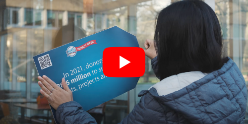 Woman places blue tag on window with a youtube play button overtop